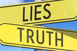 An image of two signs pointing in opposite directions, one with the word “lies” and one with the word “truth”