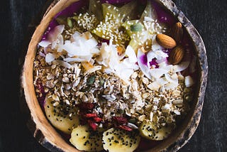 Bowl of healthy food with banana, coconut, nuts, seeds
