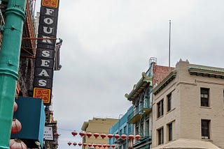 China Town San Francisco shows red chinese lanterns hanging between buildings over a closed street of street vendors in 2020.