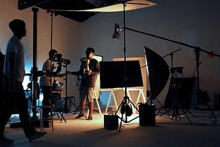 Several people working to set up a set for a video shoot