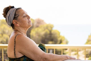 Woman with her eyes closed, and face to the sun.