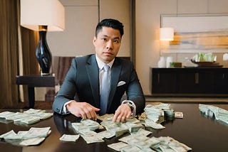 CEO of a company wearing a business suit, sitting in an executive suite in a fancy luxury hotel, looking serious, counting cash.