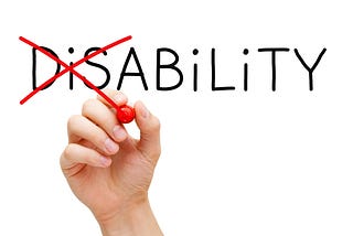 Hand turning the word Disability into Ability with red marker isolated on white.