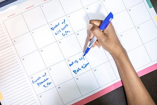 woman writing on a calendar planner