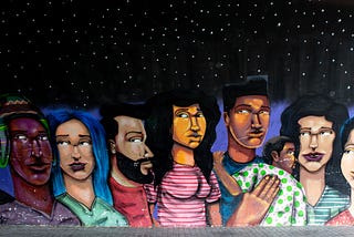 a mural depicting people gathered in a dimly lit room, showcasing unity and diversity