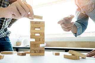 dois Product Owner construindo uma torre de madeira mostrando a importância das bases/pilares