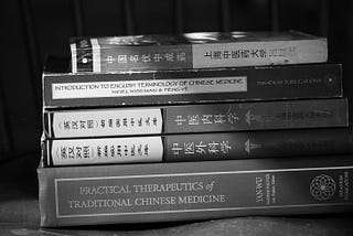 Stack of Chinese Medicine texts in English and Mandarin