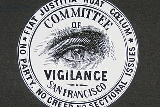 The symbol of the committee of vigilance, an all seeing eye with “committee of vigilance San Francisco” and mottos.