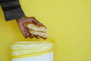 A man throwing bread in a dustbin