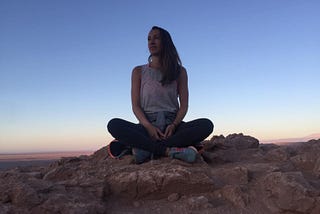 Woman sitting in the desert meditating