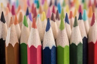 Bunch of colorful pencils facing upwards.