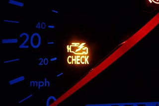 A check engine light activated on a car dashboard.
