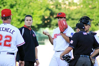 Carlos Olivas (second from the left) pays a medical visit to RoughRiders pitcher Carlos Pimentel. (Alex Yocum-Beeman)