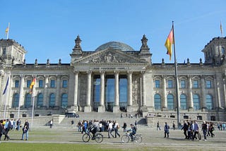 The stately Reichstag Building with the German flag flying in front, in Berlin, Germany