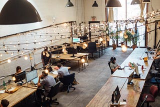 people sitting in front of computer monitors at a coworking space to fend off founder loneliness