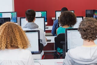 Students in class coding on their computers