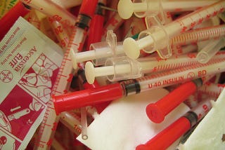 A pile of syringes used to administer insulin and alcohol swabs