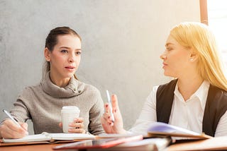 Two women talking in an office setting
