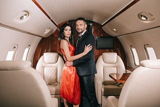 a well dressed white couple in a private jet being booshy.