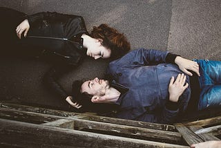 couple laying together on the ground looking at each other