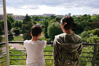 The children standing at our Parisian balcony overlooking the park.