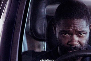 The movie poster for “The After”. The lead actor, David Oyelowo, is sitting in a car, with his hands on the steering wheel while he stares ahead.