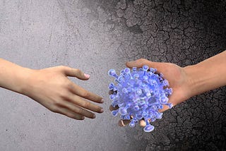 two hands about to shake hands, one holding a model of the covid virus.