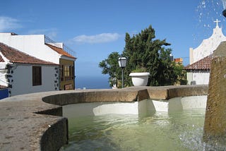 A fountain with typical Canary islands houses behind