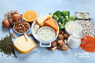 Table laden with almonds, oranges, figs, sardines, lentils, broccoli, and yes cheese. Image Source Canva Pro.
