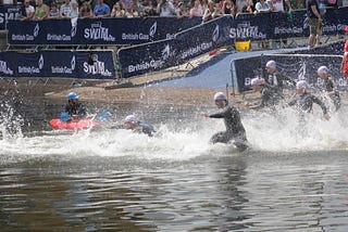 Swimmers running into the water at the start of a race.