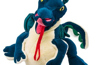 A whimsical Dragon Puppet, dark green with yellow eyes and a lolling red forked tongue hanging over a beige fluffly belly