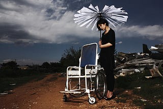 Woman holding a rotor beside a wheelchair, Can she make it fly?