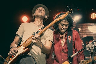 Two musicians play guitar and perform