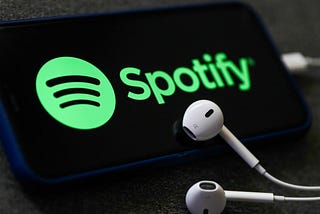 An image of a mobile phone with a Spotify logo and headphones.