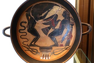 An ancient Greek black-figure kylix showing Prometheus bound to a pillar with an eagle pecking at his liver.