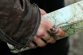 Person holding a map looking like they’re about to search for treasure