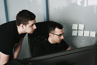 Colleagues focused on a PC screen at the office