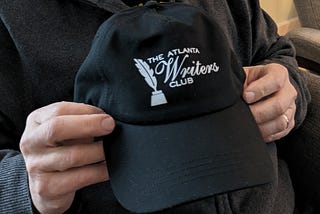 Atlanta Writers Club hat in Dave’s hands.