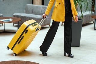 Person in a hotel lobby carrying a suitcase.