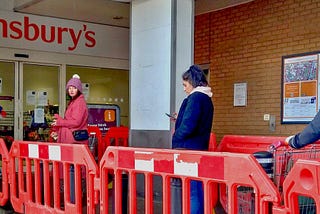 Socially-distant shoppers queueing for a Sainsbury’s.