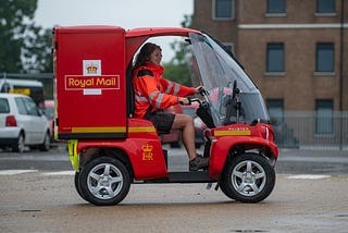 Picture of someone driving a very small royal mail car