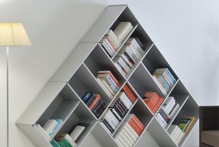 A white pyramid shape slanting bookshelf