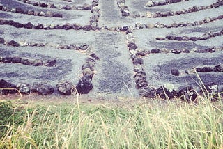 A labyrinth made of stones and sand, surrounded by grass