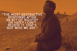 a man sitting on the beach, with the quote about disbelief in bigotry and hate being as destructive as the act itself