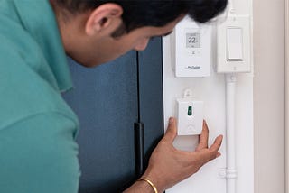 Person installing a peel-and-stick occupancy sensor