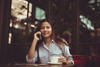 Young woman at a cafe speaking on the phone