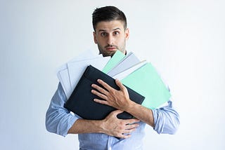 A man holding many documents.