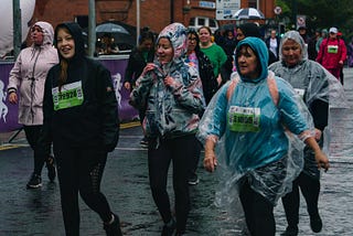a group of women running in the rain