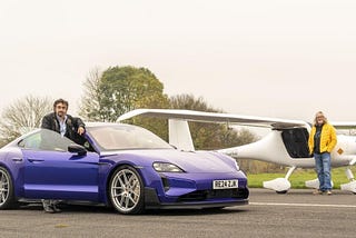 "Richard Hammond está de pie junto a un Porsche Taycan azul con matrícula RE24 ZJK, mientras James May está de pie junto a una avioneta eléctrica blanca con matrícula G-KOKO. Ambos están en una pista de aterrizaje.
