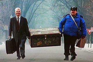 Neal and Del carry a trunk